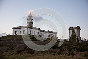 Beautiful shot of the Larino Lighthouse on a hill in Galicia Spain during sunset photo