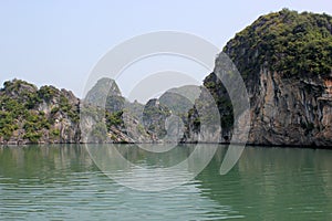 Beautiful shot of limestone islands topped by rainforests in water in Ha Long Bay, Vietnam