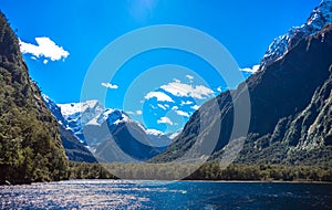 Beautiful shot of Milford Sound with snow capped mountains in the background taken on a sunny spring day, New Zealand