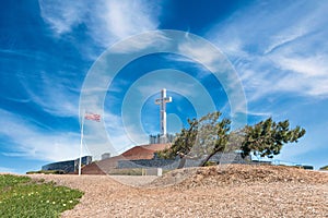 Beautiful shot of the Mt.Soledad National Veterans Memorial with a waving American flag in San Diego