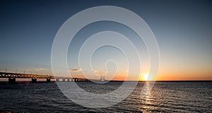 Beautiful shot of the Oresund Bridge over the sea with the sun shining in the sky