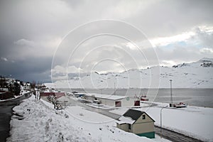 Beautiful shot of the shore of a frozen lake with ships covered in snow