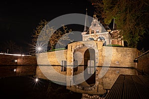 Beautiful shot of the small stone castle and its reflection on the water at night