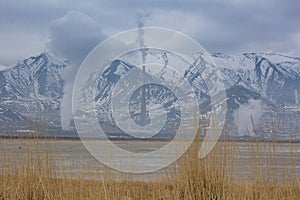 Beautiful shot of smokes from the industrial chimneys in a snowy mountains