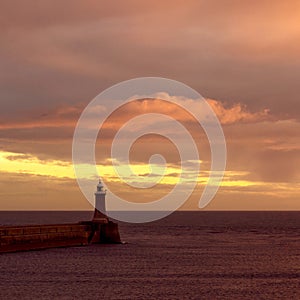 Beautiful shot of a sunrise over a lighthouse overlooking the North Sea in Tynemouth town