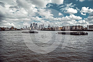 Beautiful shot of the Thames River and cargo ships with the London city skyline in background