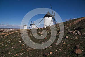 Beautiful shot of white windmills in the field under a blue sky