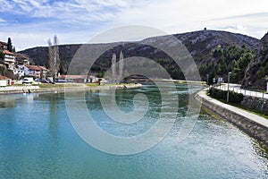 Beautiful shot of Zrmanja river surrounded by buildings and forest in Obrovac, Croatia