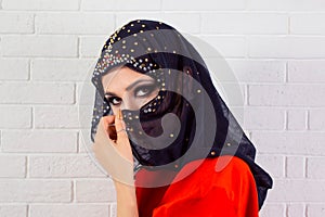 Beautiful shy muslim woman covering face with fashion veil