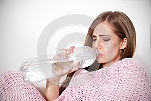 Beautiful sick woman drinking water