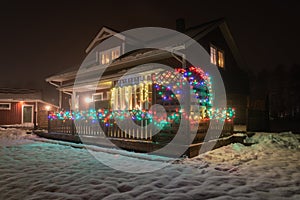 Beautiful side view at wooden red Swedish house window with traditional advent candlestick and wooden terrace fence with