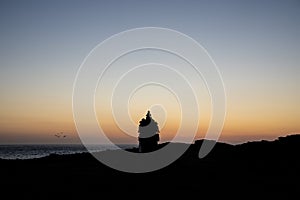 Beautiful silhouette landscape image of zen rock pile against vibrant peaceful sunset