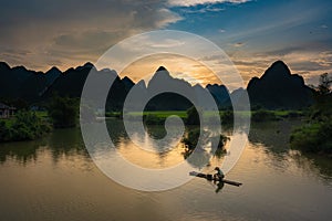 Beautiful silhouette mountains with fisherman and green rice field and river pass at the Phong Nam village in Cao Bang, Vietnam