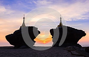 Beautiful silhouette of pagodas on rocks at sea during sunset twilight