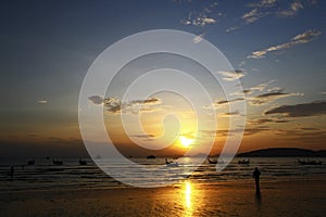 Beautiful silhouette of people, ship and long tail boat on sea or ocean with blue sky and cloud at sunset, sunrise or twilight