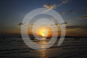 Beautiful silhouette of ship and long tail boat on sea or ocean with blue sky and cloud at sunset, sunrise or twilight time