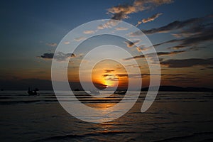 Beautiful silhouette of ship and long tail boat on sea or ocean with blue sky and cloud at sunset, sunrise or twilight time