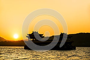 The beautiful of silhouette sunset landscape scenery of Xihu West it Lake, Sightseeing boat and pavilion in Hangzhou CHINA