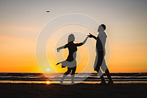 Beautiful silhouettes of dancers at sunset