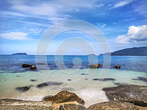 The beautiful silky smooth water waves and rocks on the sea shore.