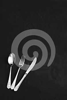 Beautiful silver fork, spoon and knife on a black background