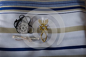 A beautiful Silver Magen David star necklaces on a white tallit with the Malchai 4:2 verses on it.