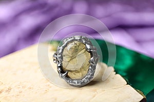 Beautiful silver ring with gemstone on textured surface