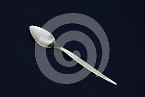 A beautiful silver spoon on black background. Closeup
