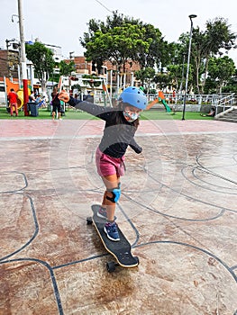 Beautiful skater girl with her protection helmet riding her longboard in the city.