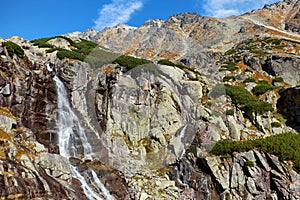 The beautiful Skok waterfall with the mountains of High Tatras