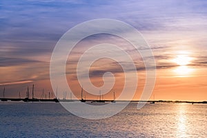 Beautiful sky in the bay in the city of Faro in Portugal. Silhouettes of yachts and boats at sunset near the water