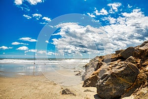 A beautiful sky, beach and rock on a groin at Pawleys Island.