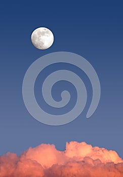 Beautiful sky landscape with white full moon high on clear blue gradient sky above red clouds on sunset