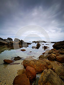 Beautiful sky over ocean water with rocks