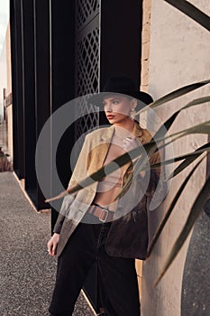 beautiful slavic woman with dark hair in casual clothes and black hat posing in the street of Limassol