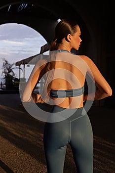 beautiful slavic woman with dark hair in elegant sportive suit posing in the arch