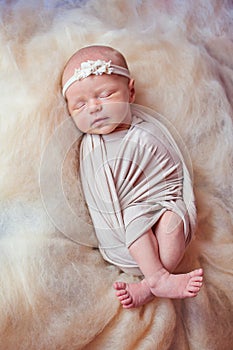 Beautiful sleeping newborn girl with a bandage on his head