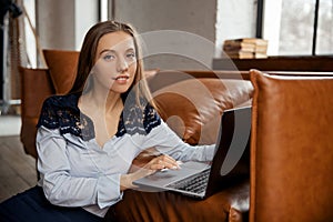 Beautiful slim elegant young business woman working remotely from home using laptop