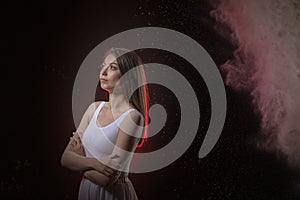 Beautiful slim female dancer in studio during Powder Photo Shoot with colored light