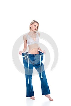 beautiful slim girl in old jeans with measuring tape,