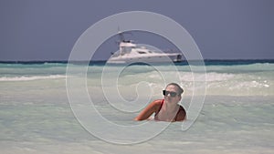 Beautiful Slim Woman in Red Swimsuit Bathes and Rests in Ocean on Paradise Beach