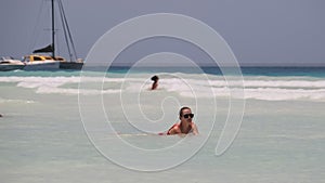 Beautiful Slim Woman in Red Swimsuit Bathes and Rests in Ocean on Paradise Beach