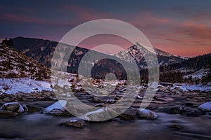 Krivan peak with the moon in full over a mountain river in High Tatras