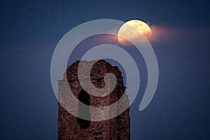 The ruins of the church tower and the moonrise in full moon