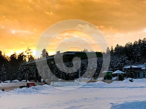 Beautiful small gas station for refueling cars with fuel, gasoline and diesel at sunset in the winter