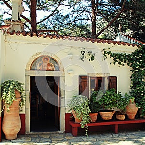 Beautiful small greek chapel with flower pots (Crete, Greece)