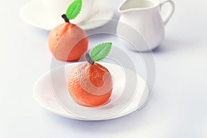 Beautiful Small Mousse Cake in Shape of Citrus Mandarin Tasty Modern Dessert Pastry White Blue Background Cup of Coffee