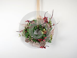 Small Christmas flower wreath on white background. photo