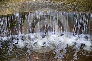 Beautiful small waterfall with cascades in Reina Sofia Park, Guardamar del Segura. Valencia, Spain.