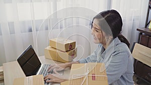 Beautiful smart Asian young entrepreneur business woman owner of SME online checking product on stock and save to computer working